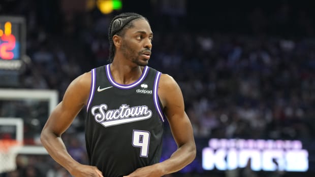 Justin Holiday tucks in his black Sacramento Kings jersey.
